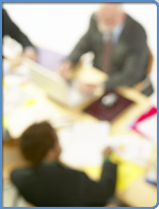 Blurred photo of professionals in a meeting setting.