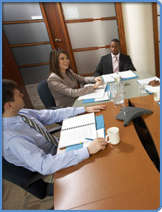 Three business professionals in a meeting setting.