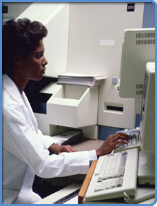 Lab technician working at a computer.